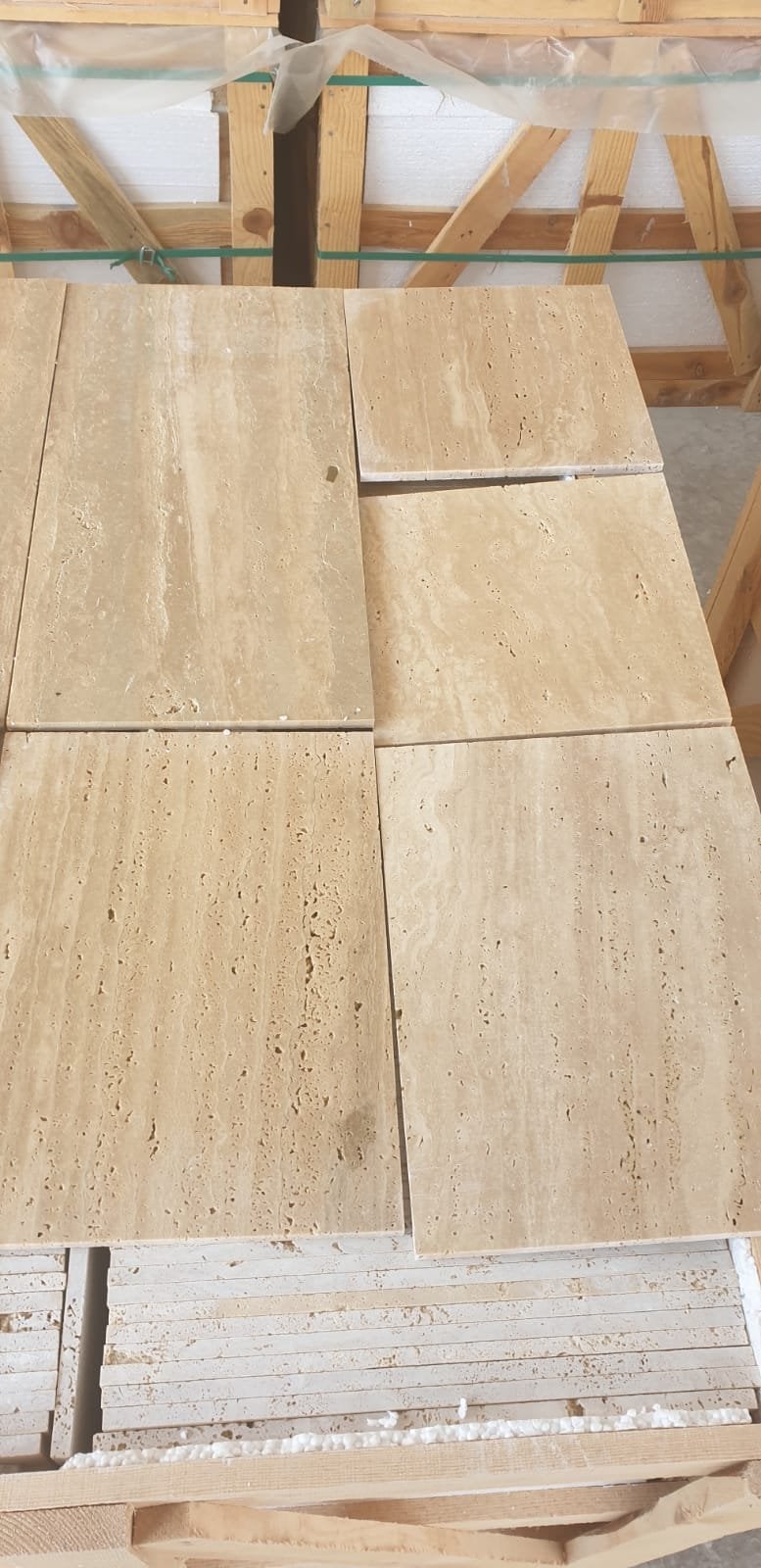Light travertine honed: strips on a pallet, straight veining visible