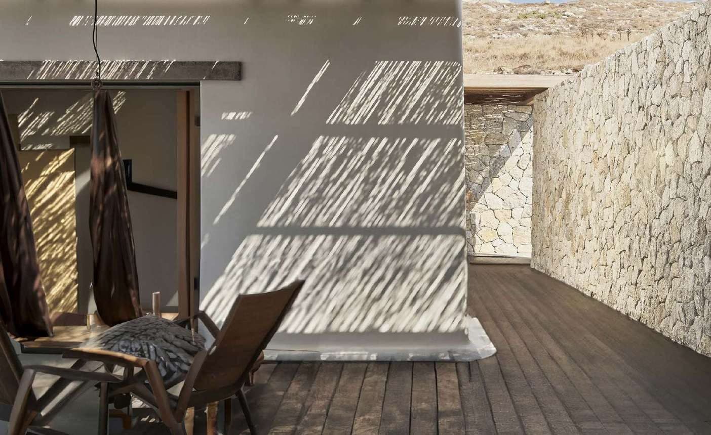 Terras met een wand van lichte polygonale travertin en houten plafond