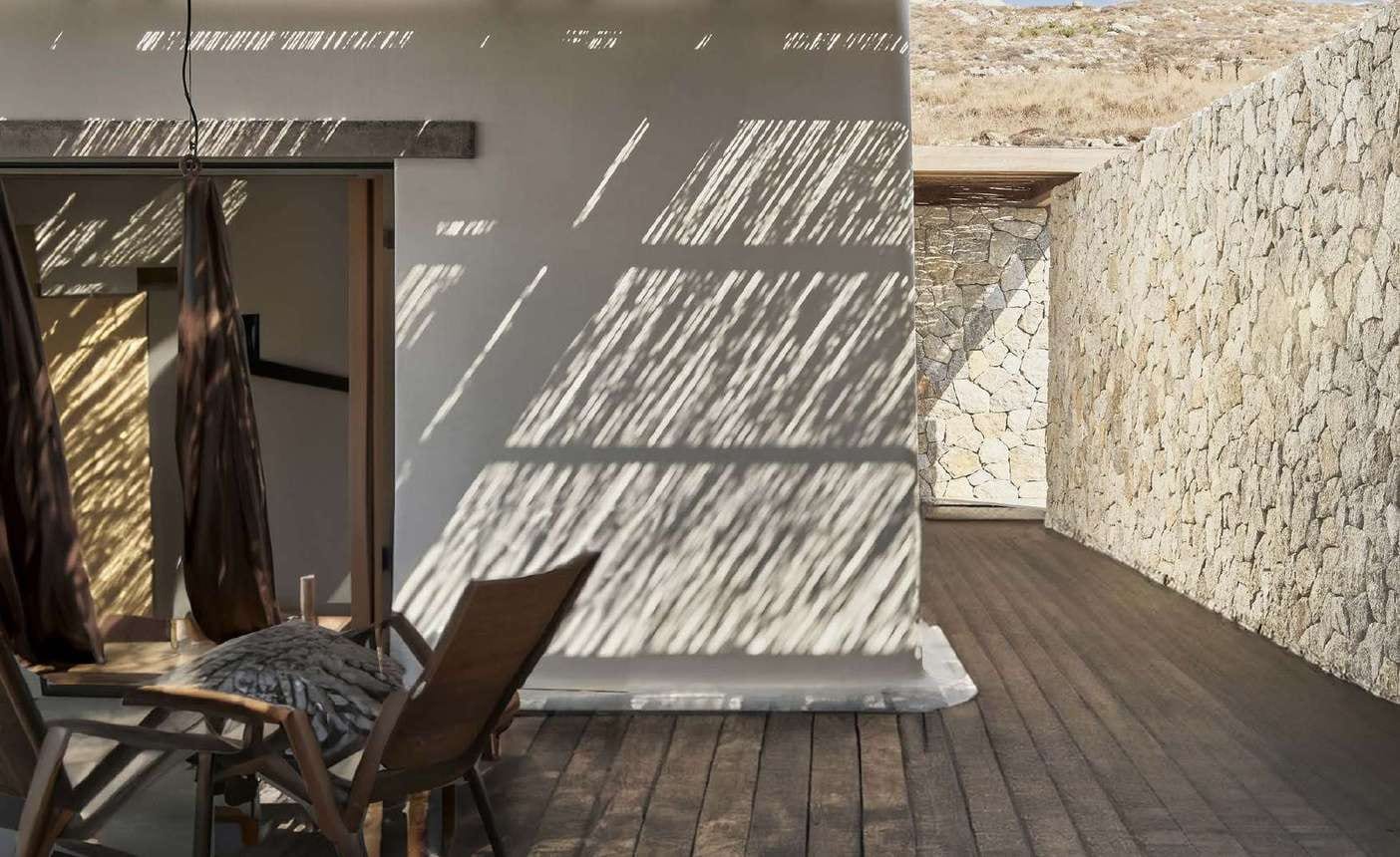 Terrace with a wall of light polygonal travertine and a wooden ceiling