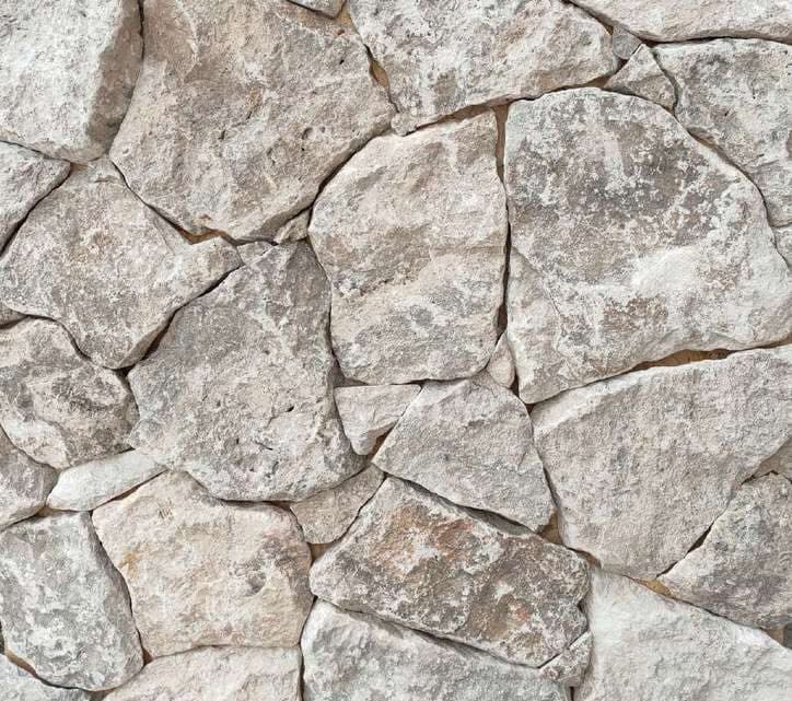 Rockface Silver: polygonale zilvergrijze travertin stukken met breukvlak, als wand gelegd