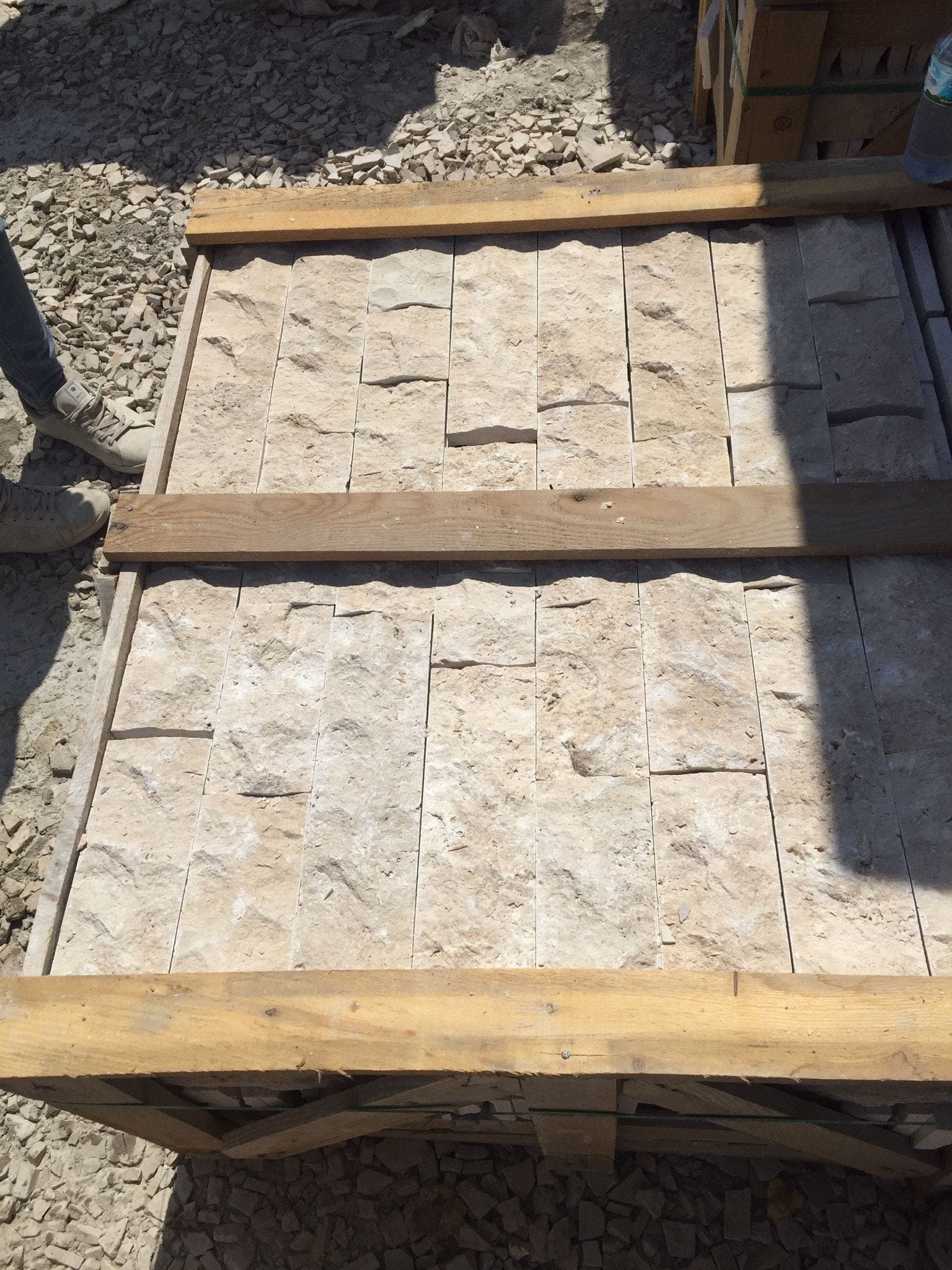 Splitface strips Light: lichte travertin strips met breukvlak in kist