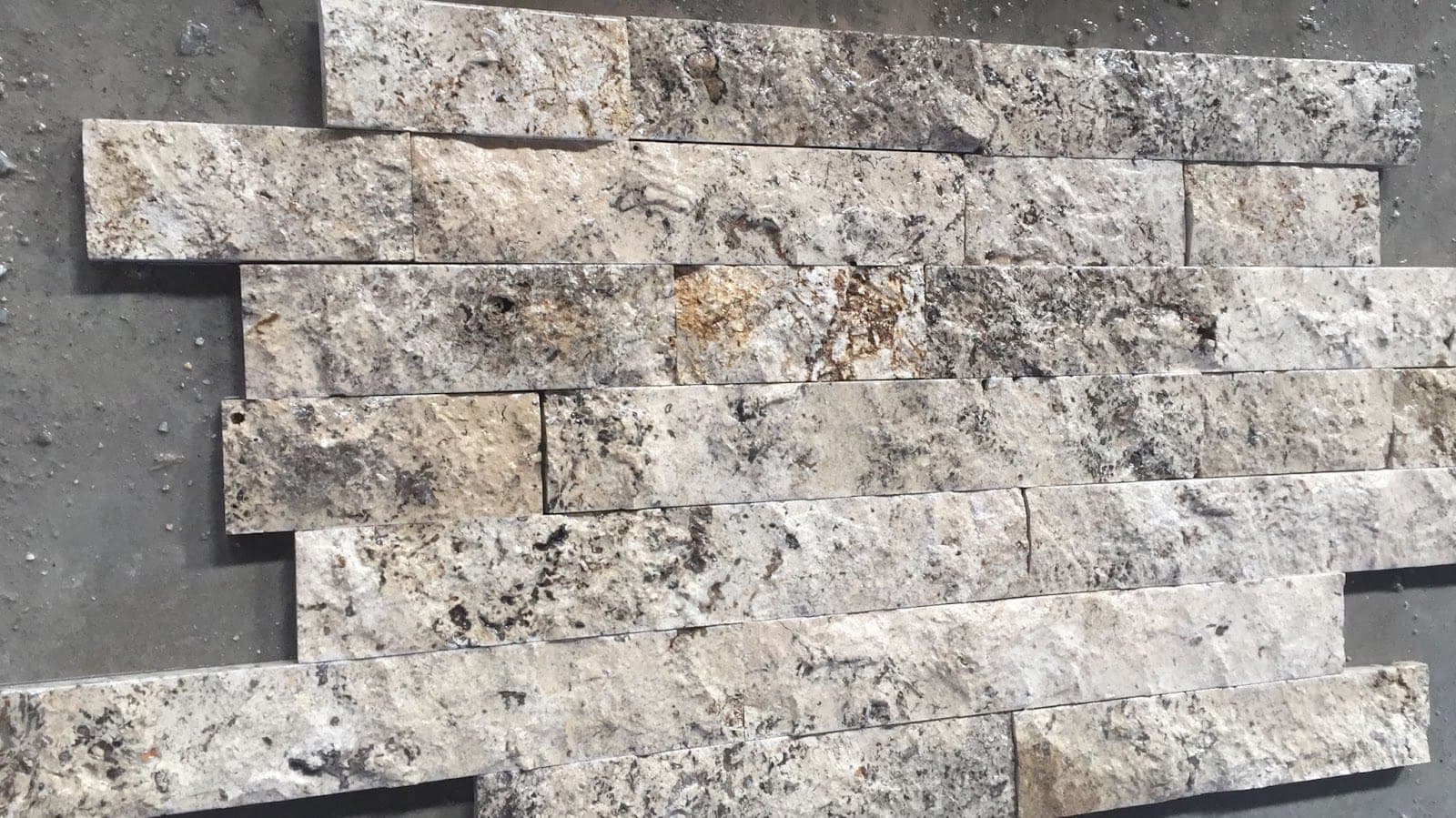 Splitface strips Silver: zilvergrijze travertin strips met ruw breukvlak, gestapeld als wand