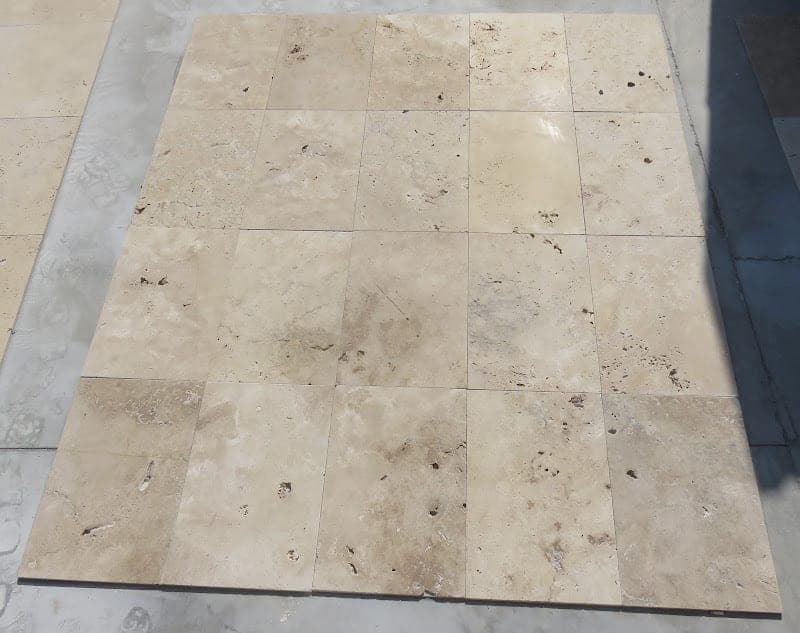 Terrastegel Light 40,6 × 61 cm: close-up van getrommelde lichte travertin met natuurlijke gaatjes