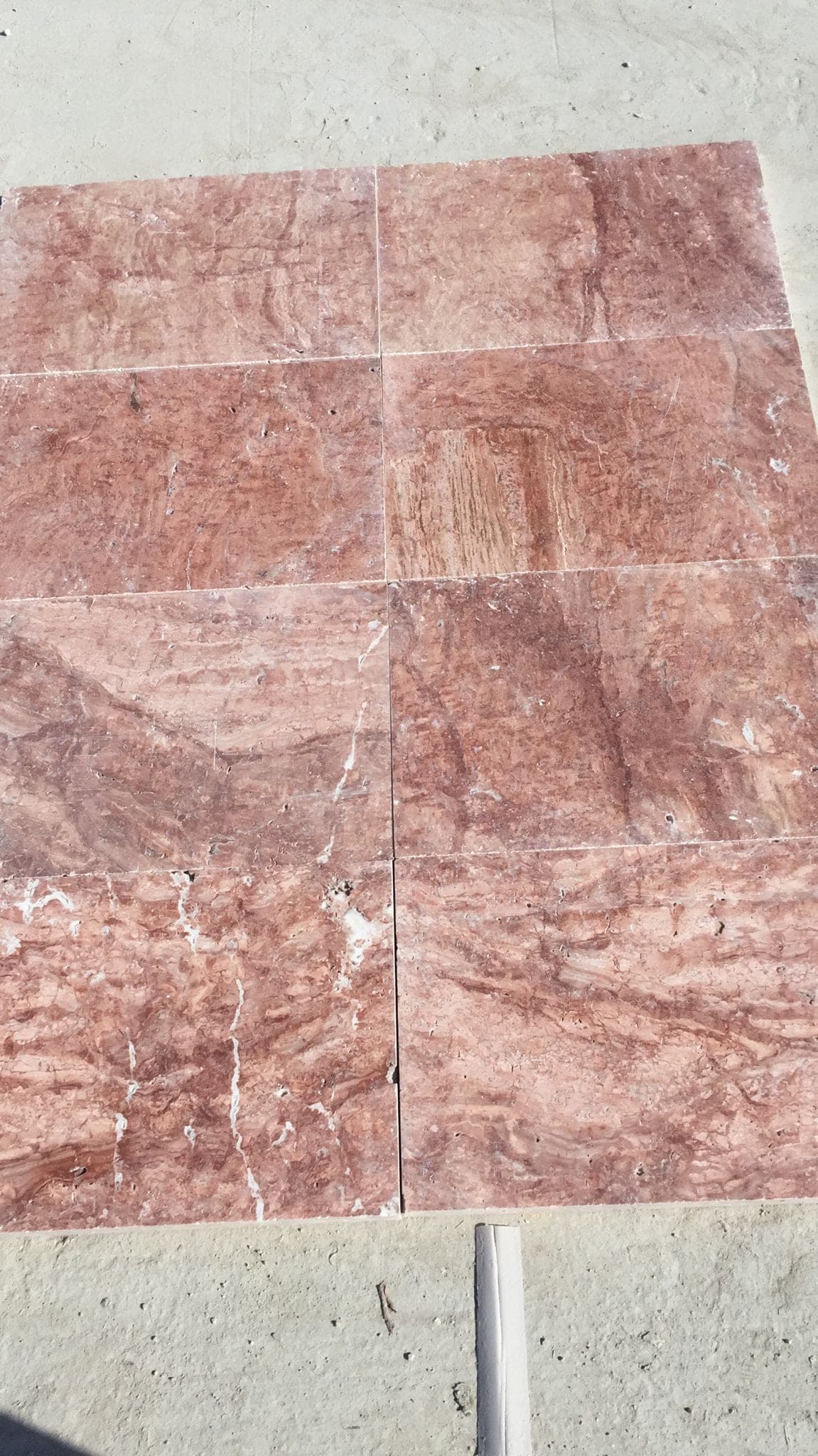 Terrastegel Rosso 40,6 × 61 cm: close-up van rode travertin met crème aders