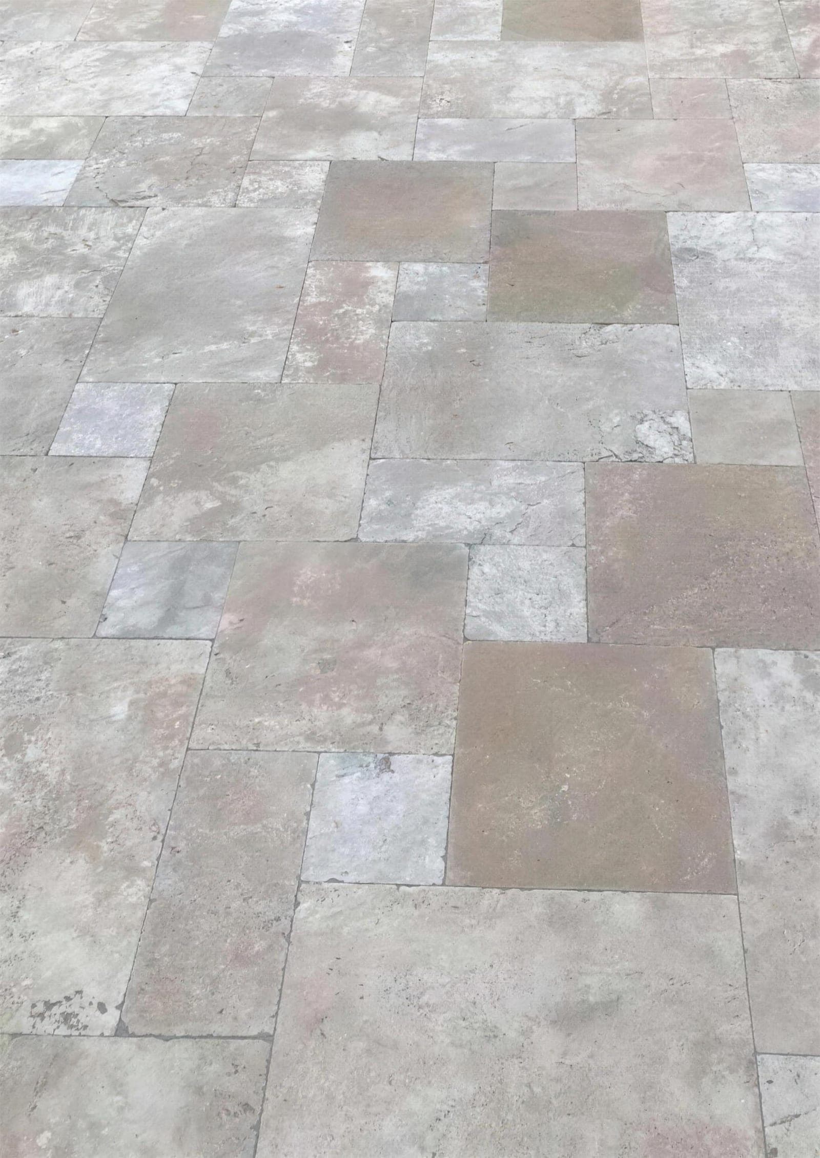 Titanium cross-cut: donkergrijze travertin met lichtgrijze wolken, getrommeld, gelegd in Frans verband
