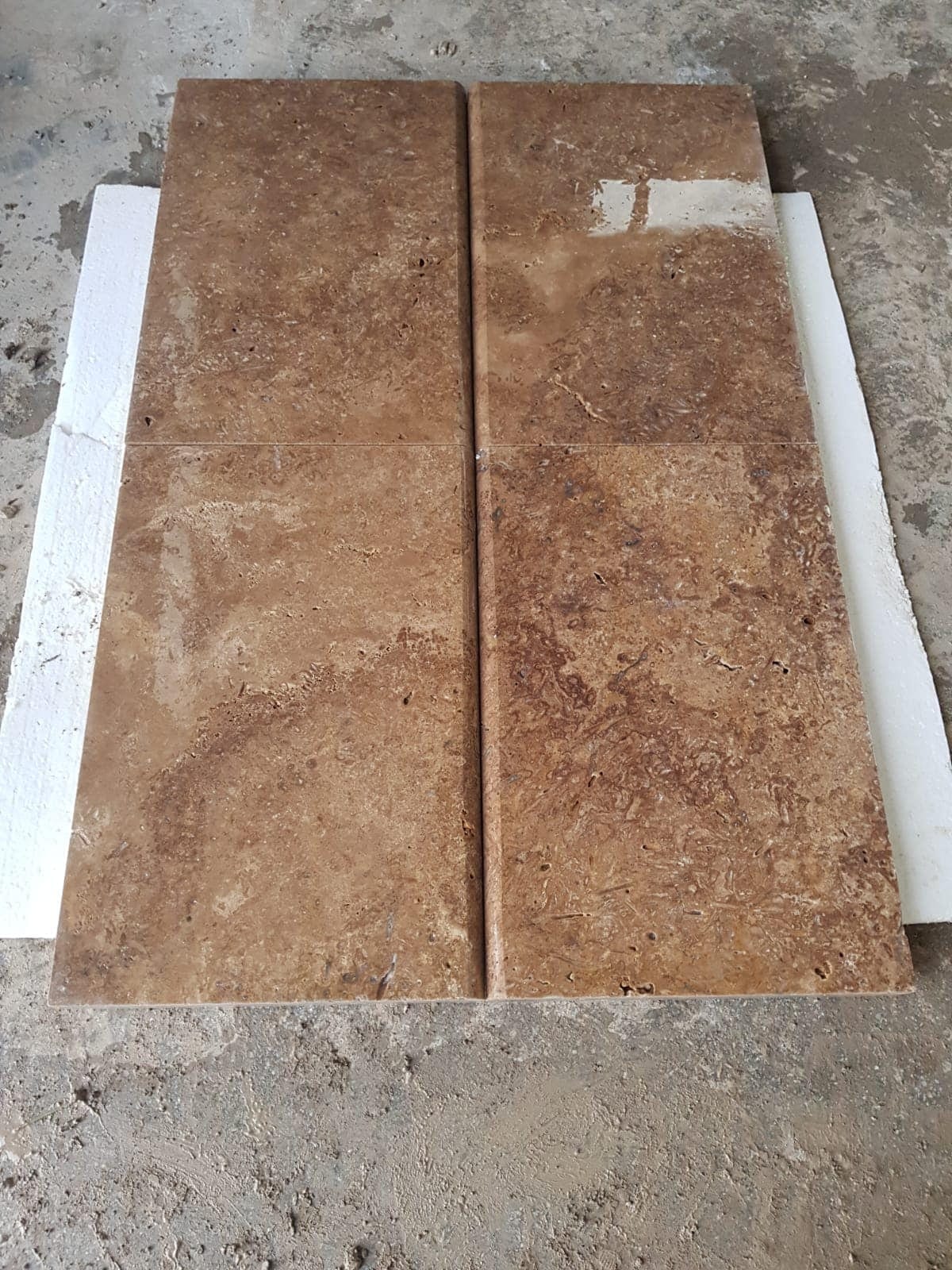 Walnut pool coping: walnut-brown coping stones with rounded front edge, tumbled