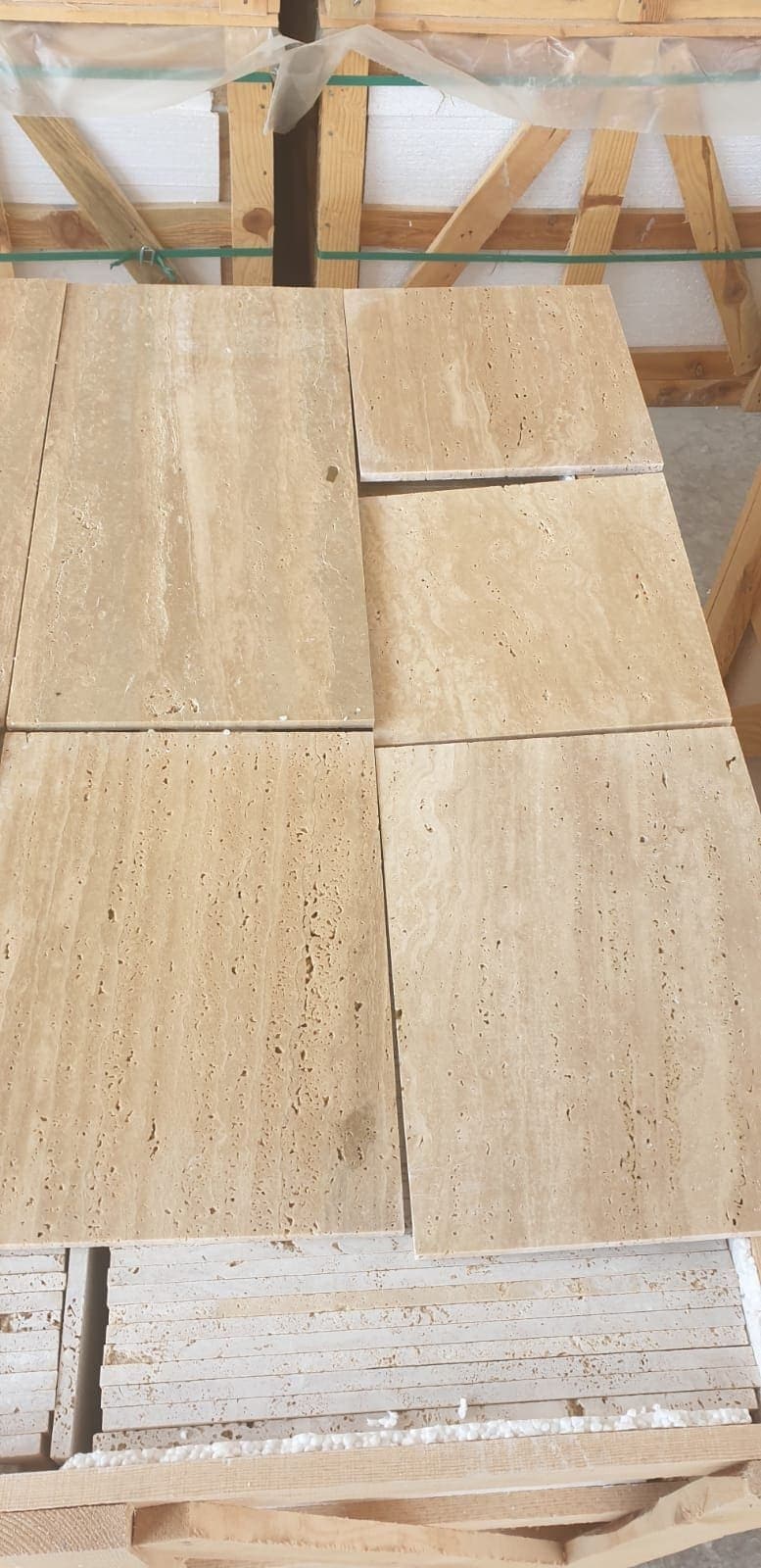 Light travertine honed: strips on a pallet, straight veining visible